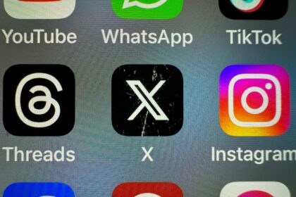 In this photo illustration the logo of US online social media and social networking site 'X' (formerly known as Twitter) is displayed centrally on a smartphone screen alongside that of Threads and Instagram